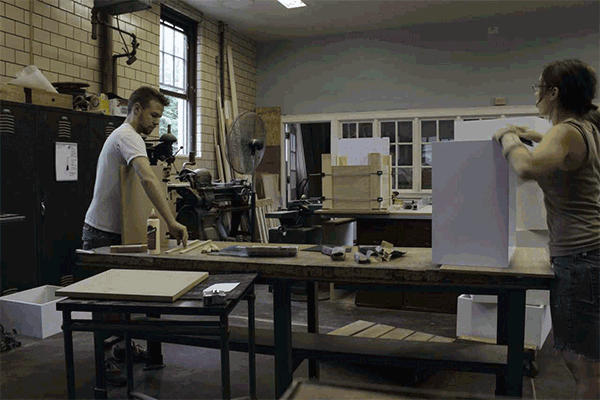 Justin Lacey and Miriam Devlin, co-owners of Day Shift Furniture, assemble one of the 34 boxes that make up the Carnegie Mellon shelving. Photo Credit Miriam Devlin.