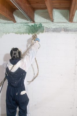 Jose Ramirez, a worker with Chicago Green Insulation, sprays foam insulation onto the walls of the Lyczko’s home. It hardened and became part of the structure.